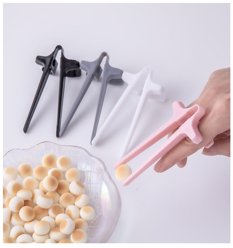 Set of star-shaped tongs in black, gray, and pink being used to pick up snacks from a bowl.
