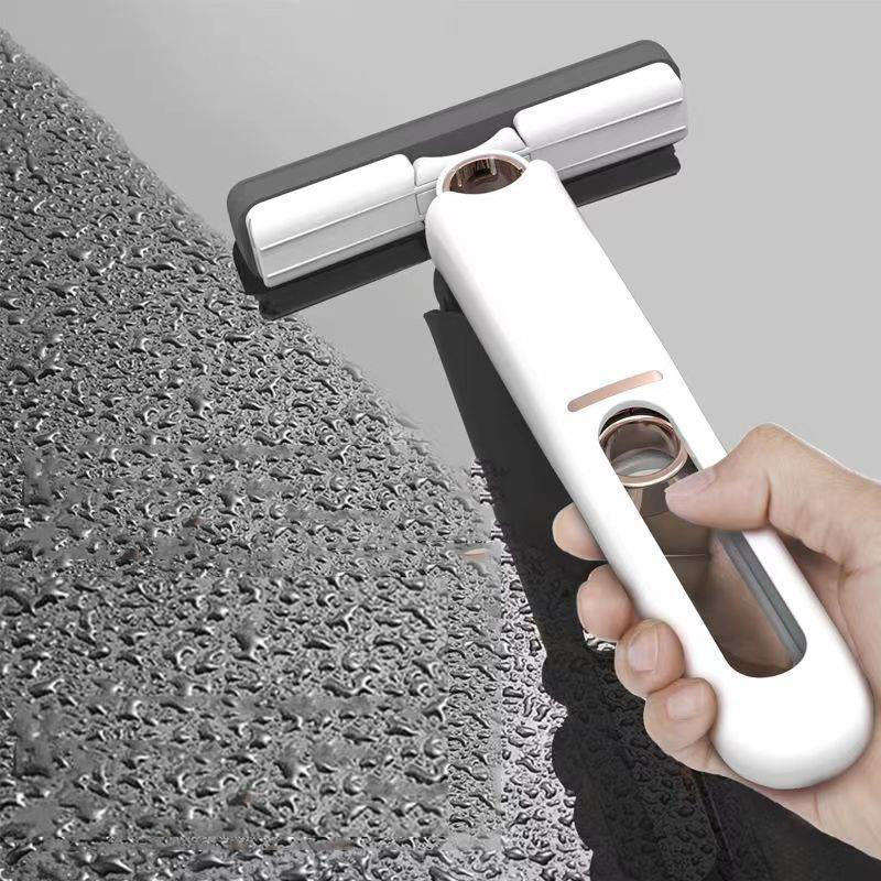 Hand holding a window cleaning tool against a textured glass surface