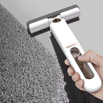 Hand holding a window cleaning tool against a textured glass surface