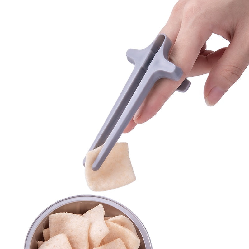 Hand using a gray dumpling wrapper press tool to shape dumplings.